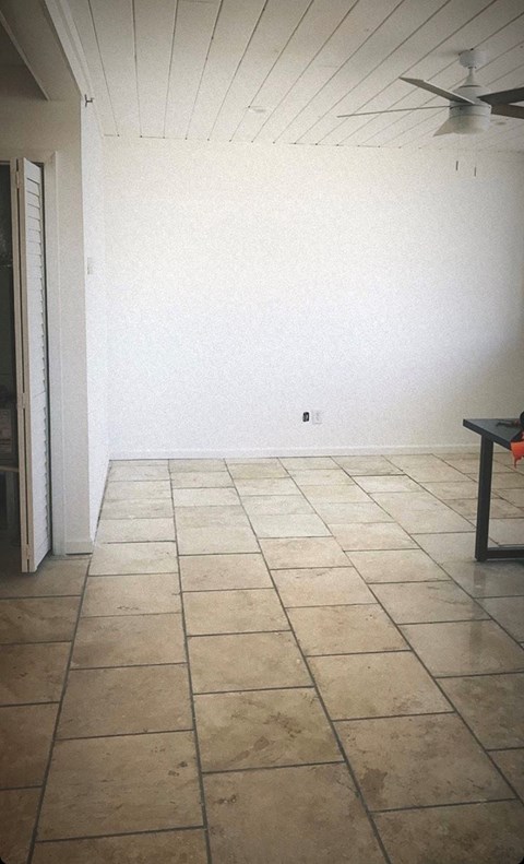 A room with a tiled floor and a ceiling fan.