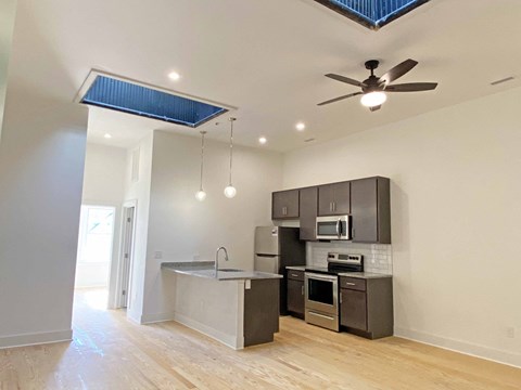 A kitchen with a ceiling fan and a microwave oven.