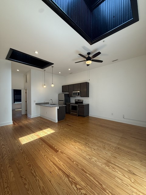 A room with wooden floors and a ceiling fan.
