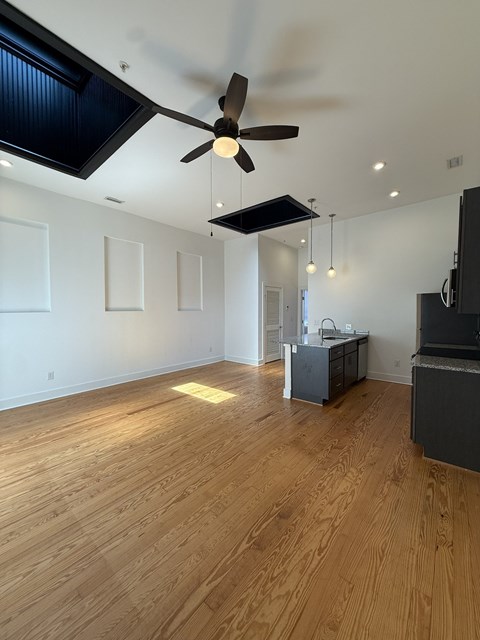A room with wooden floors and a ceiling fan.