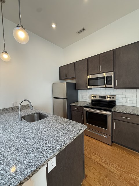 A kitchen with granite countertops and stainless steel appliances.