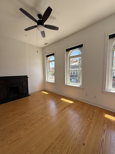 A room with a fireplace and a ceiling fan.