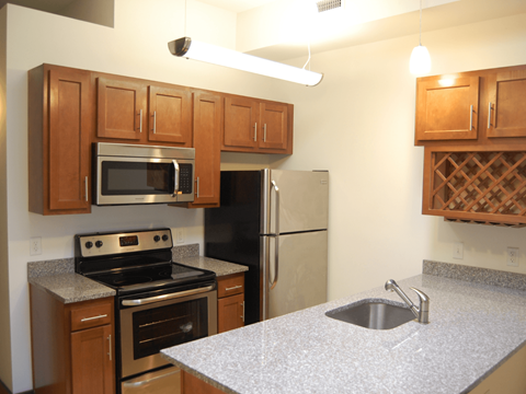 A kitchen with a stove, refrigerator, and microwave.