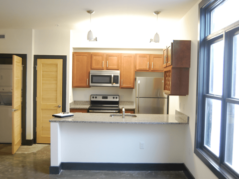 A kitchen with a white counter and wooden cabinets.