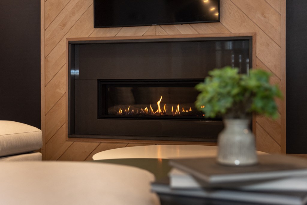 a fireplace with wood paneling and a vase of flowers on a coffee table