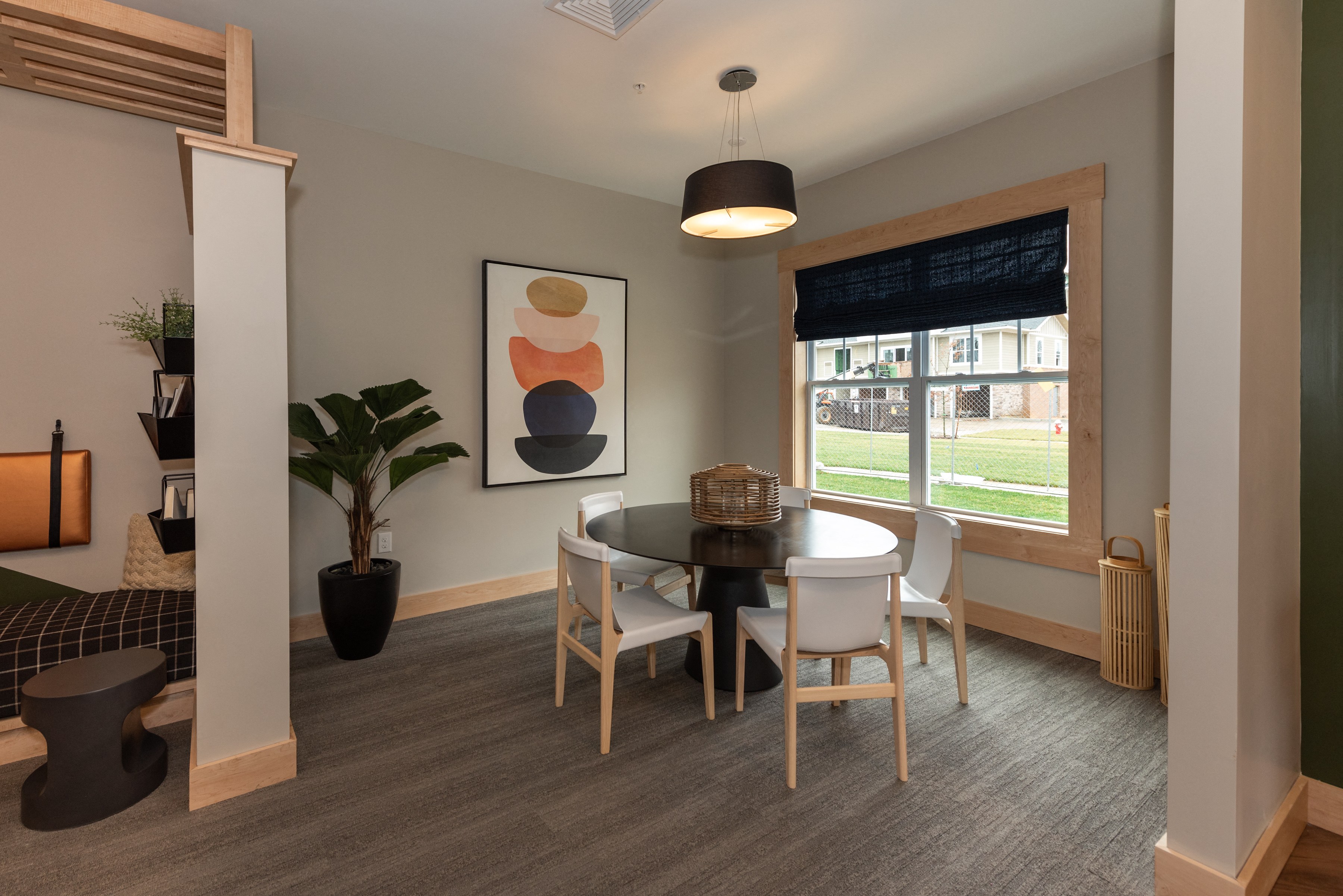 a room with a table and chairs and a painting on the wall