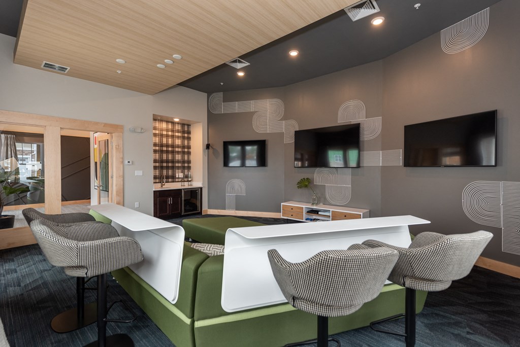 a room with a green sofa and two white tables and chairs