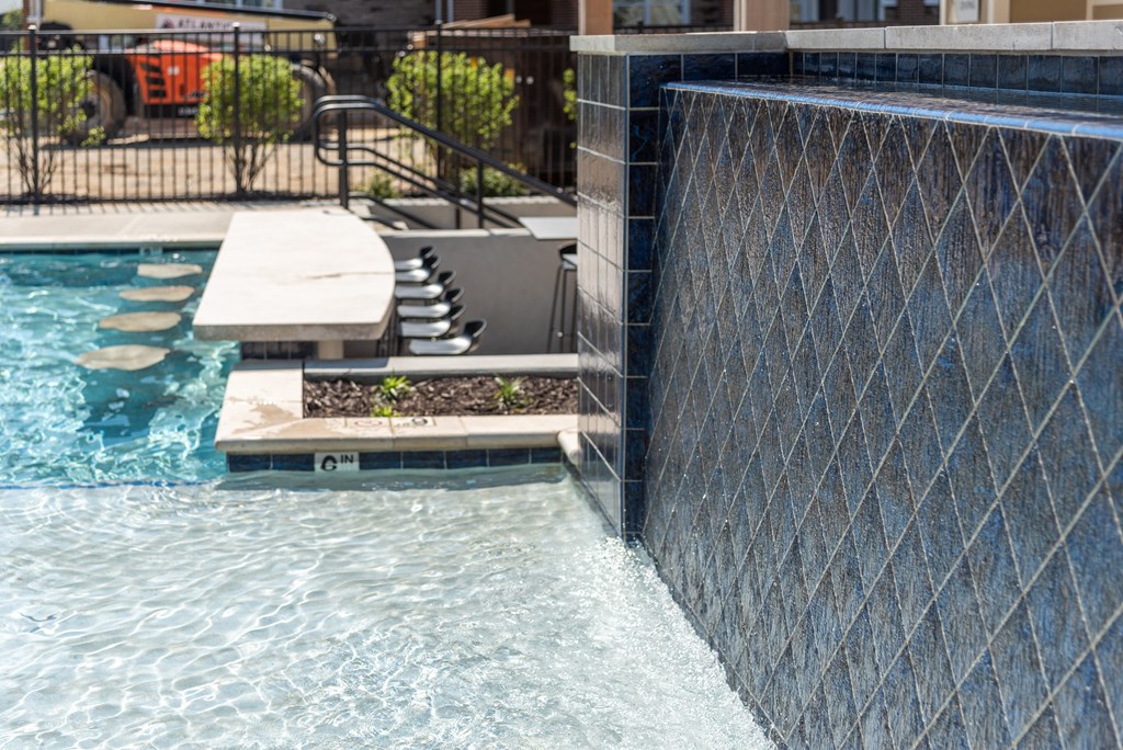 a swimming pool with a retaining wall and a water feature
