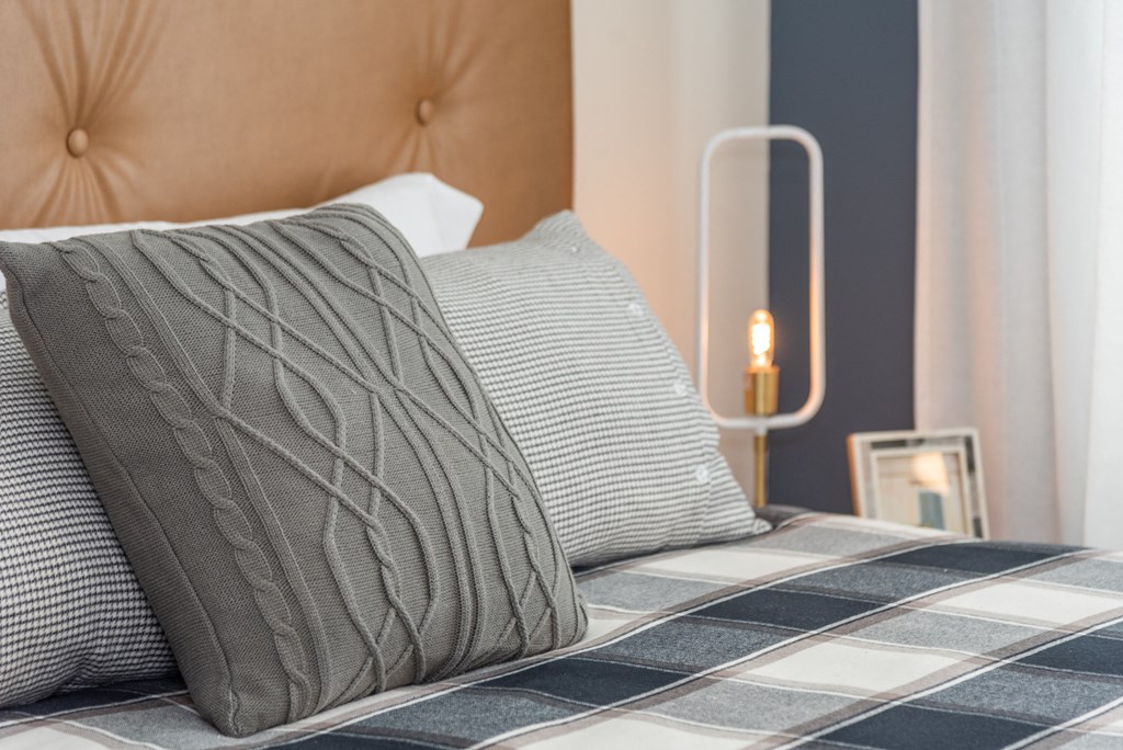 a bedroom with a bed with two pillows and a lamp on the side of the bed