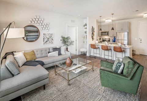 A modern living room with a grey sofa and a green armchair.