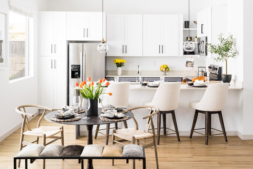 a kitchen and dining area with a table and chairs and a refrigerator