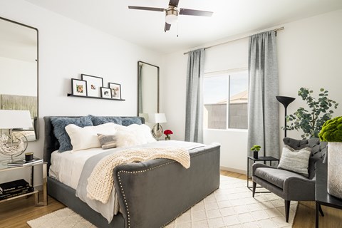a bedroom with a bed and a chair and a ceiling fan at Onyx at Westgate Apartments, Glendale, AZ, 85305