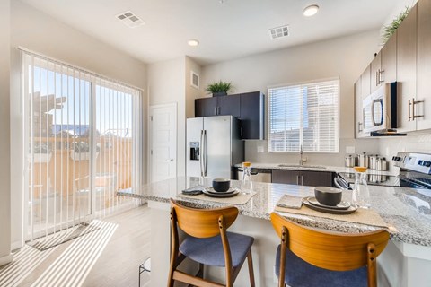 A modern kitchen with a dining table and chairs.