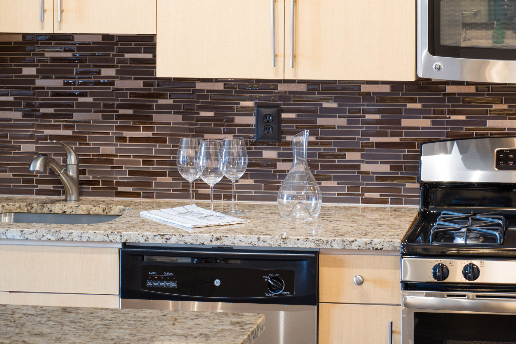 A kitchen with a black oven and a black dishwasher.