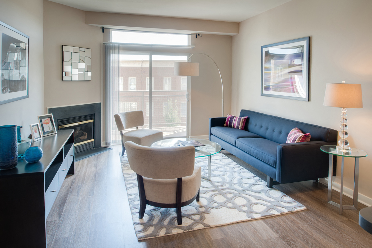 A living room with a blue couch and a fireplace.