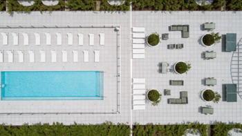 A swimming pool is surrounded by a white wall and a white fence.