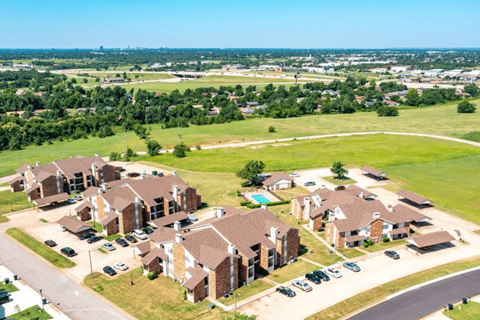 A large housing development with multiple houses and cars parked in front.