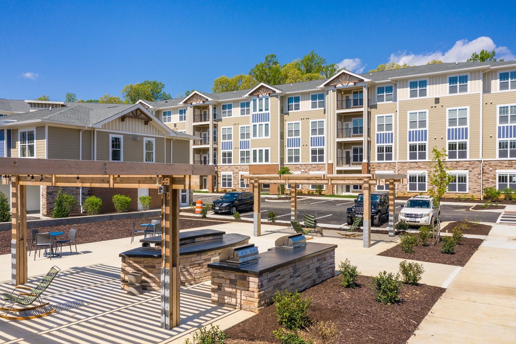 an outdoor patio with a firepit and picnic table at the enclave at woodbridge apartments in