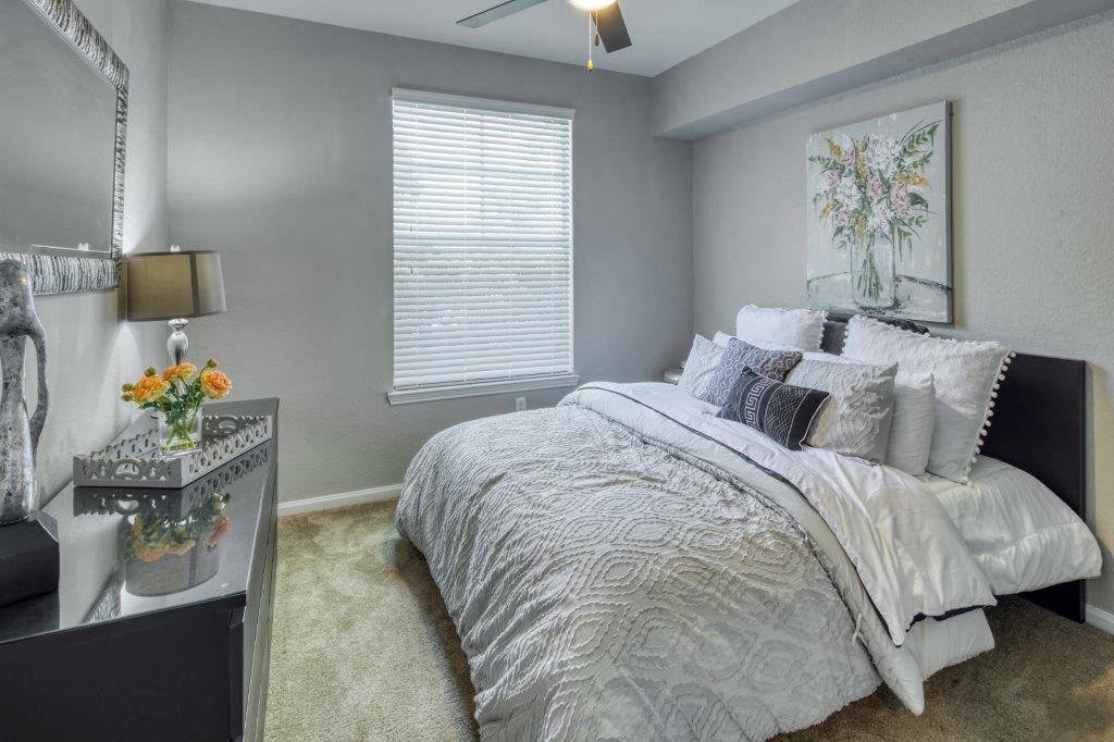 a bedroom with a bed and a dresser and a window