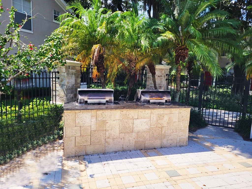 two hot tubs sitting on a stone wall in front of a fence