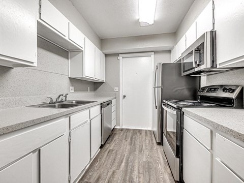 a kitchen with white cabinets and stainless steel appliances