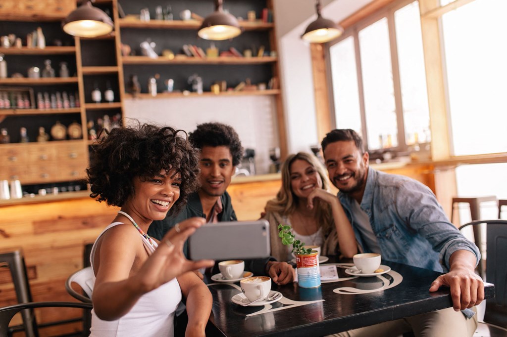 a group of people sitting at a table in a restaurant taking a picture of themselves