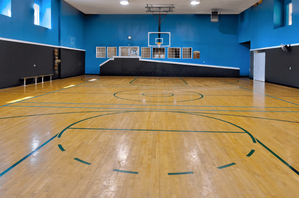 an indoor basketball court with a basketball hoop in the middle