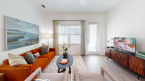 A living room with a couch, a coffee table, and a painting on the wall.