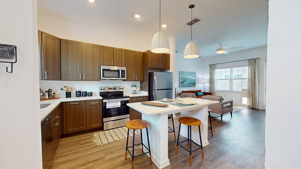 A modern kitchen with wooden cabinets and a white island.
