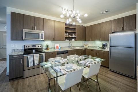 a kitchen with stainless steel appliances and a glass dining table
