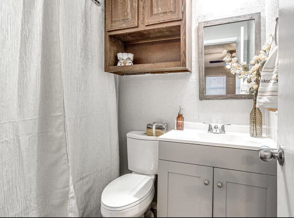 a bathroom with a toilet and a sink and a mirror