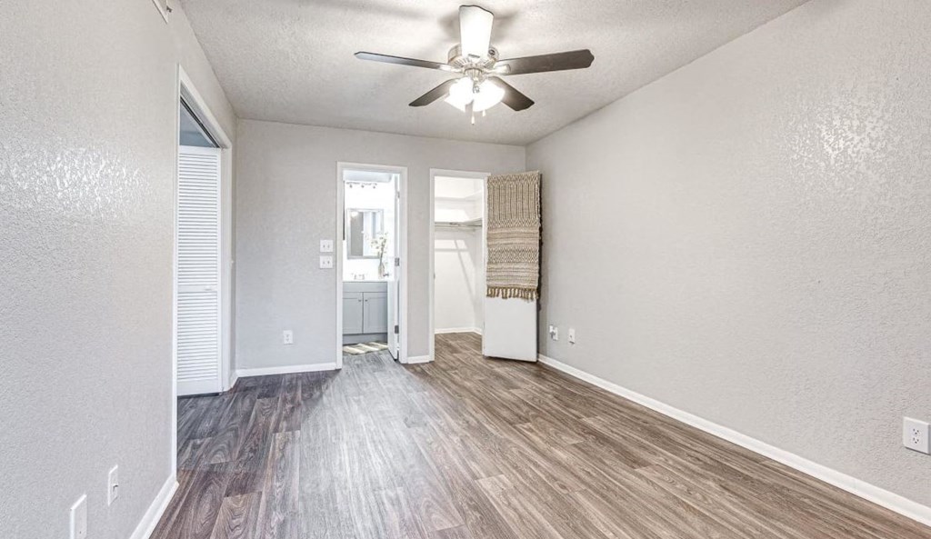 an empty living room with a ceiling fan