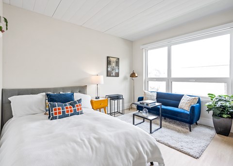 A bedroom with a large bed and a blue couch.