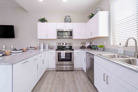 A modern kitchen with white cabinets and stainless steel appliances.