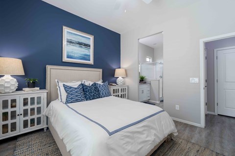 A bedroom with a white bed and blue accents.