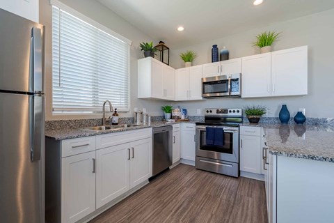 A modern kitchen with white cabinets and stainless steel appliances.