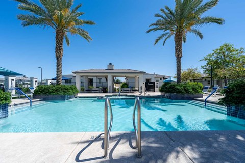 Pool area with entry stairs and palm trees at Vistoria On Mountain View Apartments, Arizona