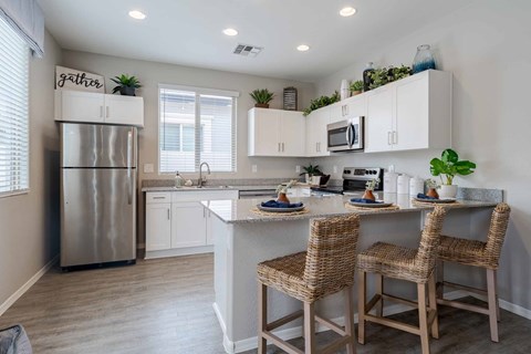 A kitchen with a refrigerator, sink, and countertop.
