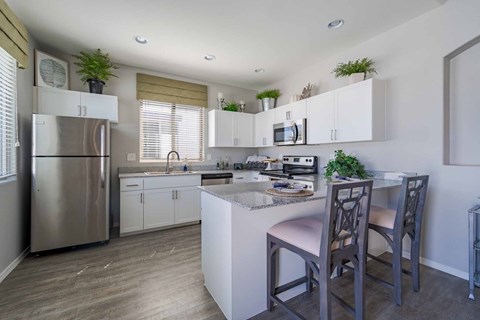 Modern kitchen with granite island seating at Vistoria On Greenway Apartments, Surprise, 85379