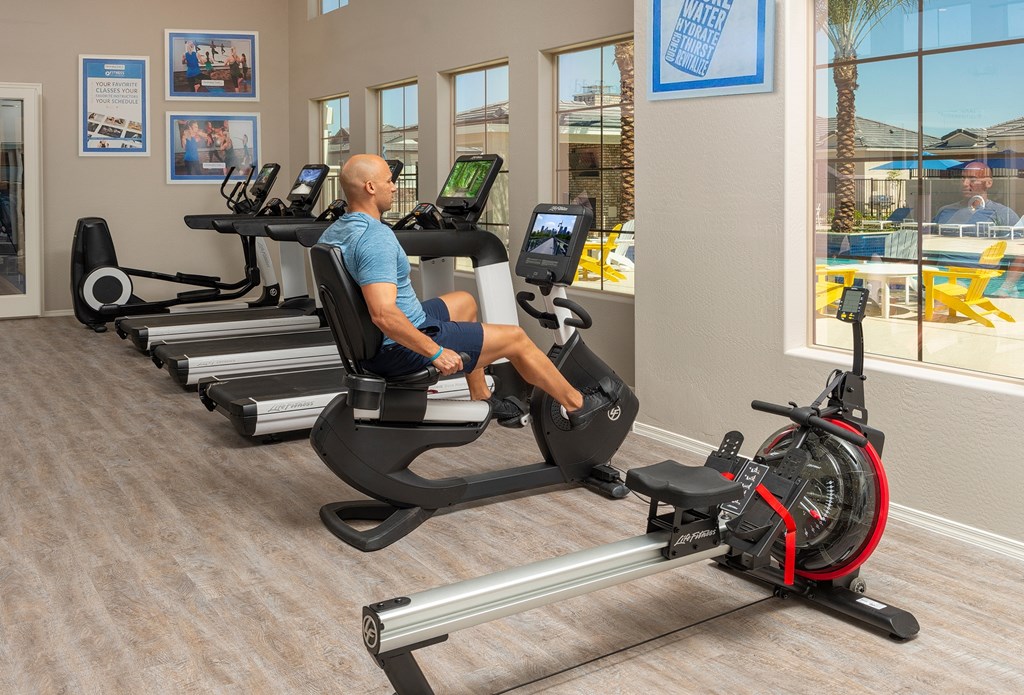 a man is sitting on an exercise bike in the gym at a health club