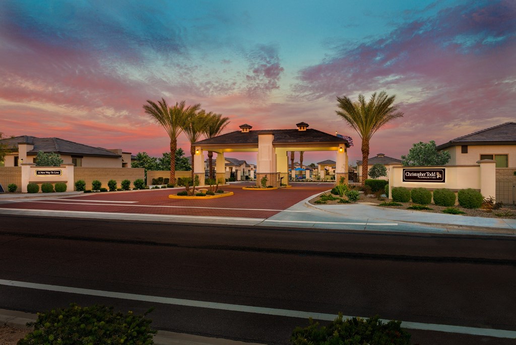 a parking lot with a building and palm trees at sunset