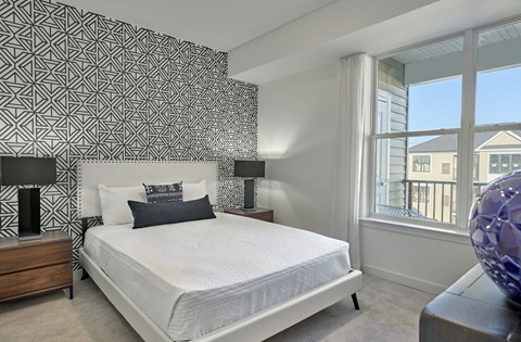 a bedroom with a white bed and a large window