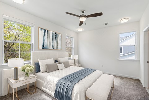 A bedroom with a large bed and a ceiling fan.