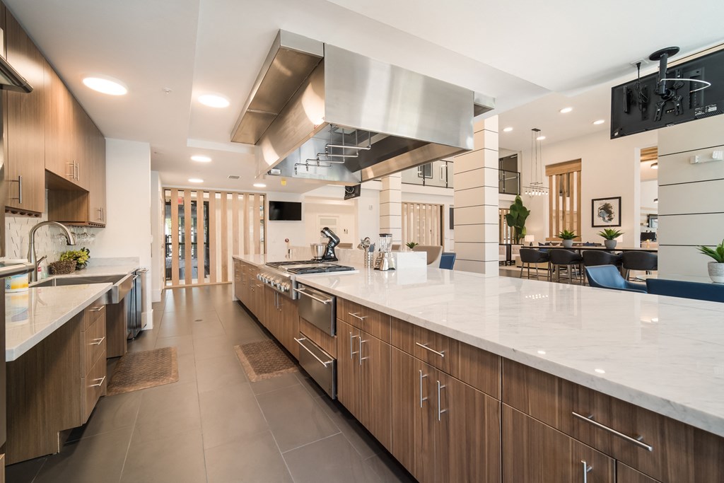 a large kitchen with a large island and stainless steel appliances at Magnolia Square, Naples, FL