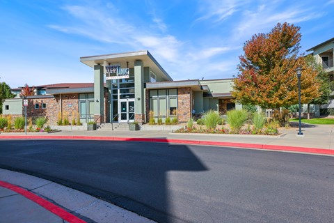 A modern building with a glass entrance and a red line on the road in front.