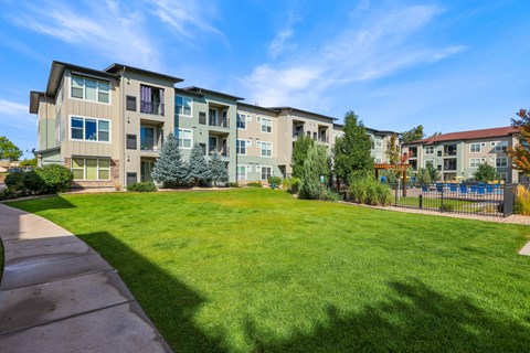 Apartment complex with a green lawn in front.