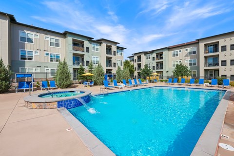 A large swimming pool in front of apartment buildings.