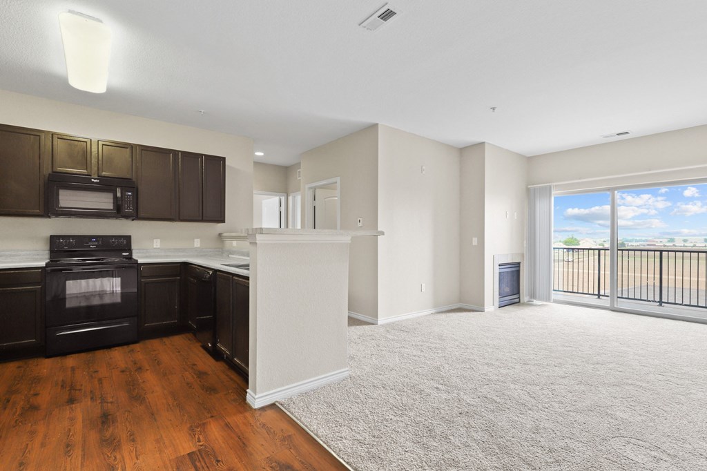 a kitchen and living room with a balcony