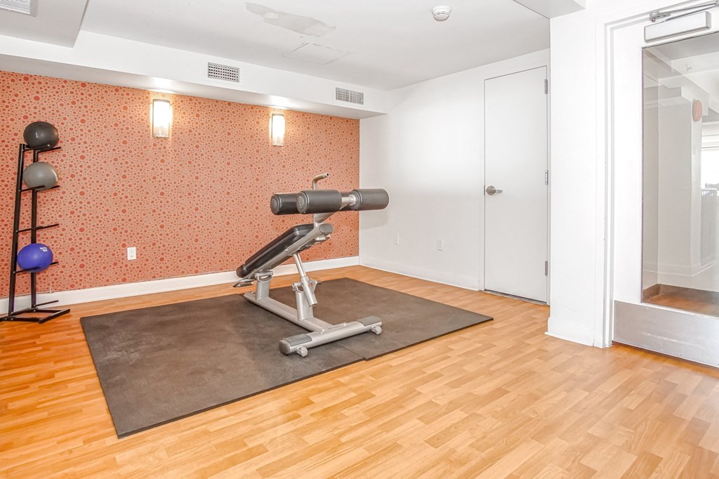 gym area with a weight machine and mirror at 10 West Apartments, Long Beach, New York
