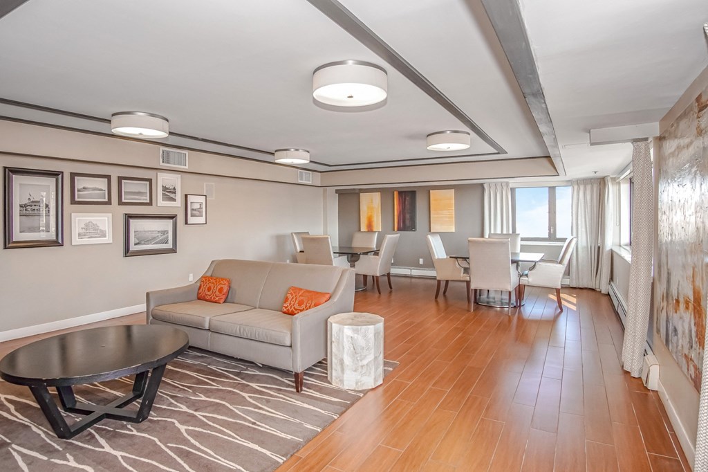 a living room with a couch and a table with chairs at 10 West Apartments, Long Beach, NY, 11561
